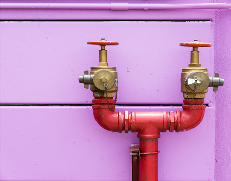 Double head fire hydrant near the wall of urban village.の写真素材