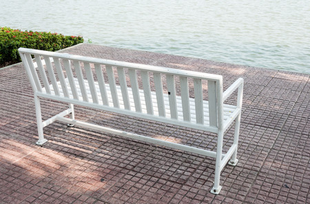 White bench near the tranquil lake.の写真素材