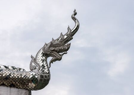 Dragon head sculpture with silver mosaic in the traditional Thai style.の写真素材