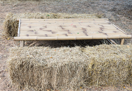 Bamboo table with  straw briquette of the farmer house.の写真素材