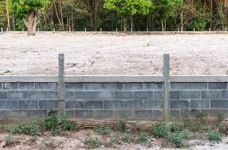 Concrete wall with sandy soil for reclamation near the border of forest.の写真素材