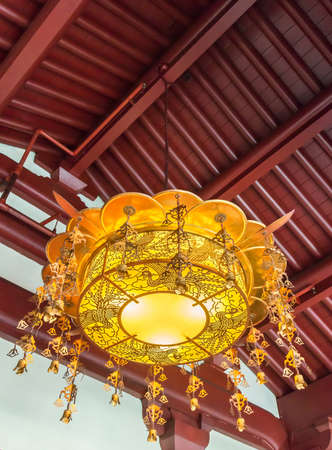Traditional Chinese lantern is hanging on the roof of temple.の写真素材