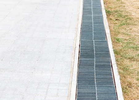 New metal grille over the drainage near the walkway of urban park, select focus.の写真素材