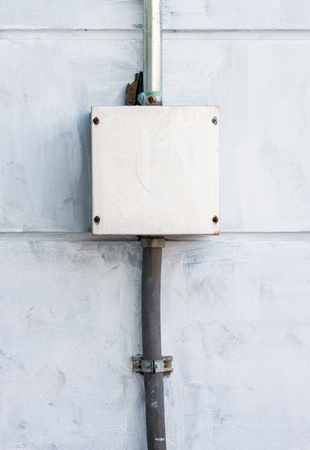 Electrical control box on the cement wall of the factory.の写真素材