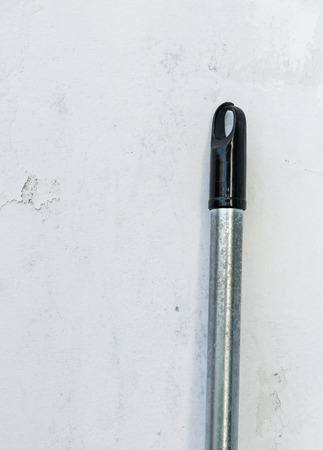 Dirty metal handle of the old swab near the house wall.の写真素材