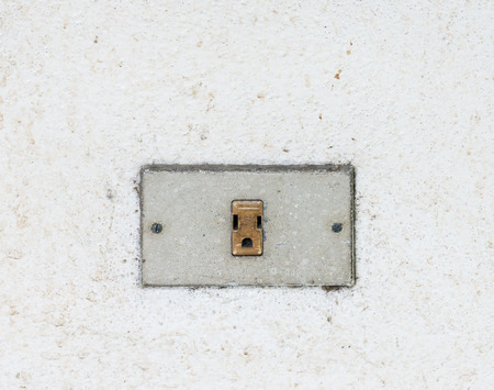 Old dirty outlet on the house wall.