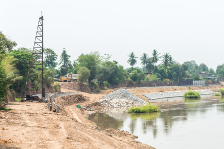 The construction site for built the protection dam near the river bend.の写真素材