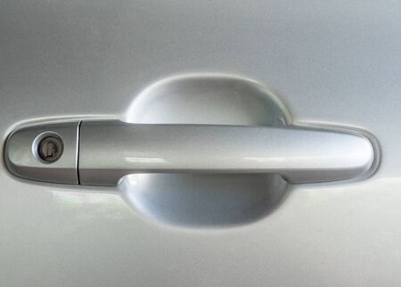 Glassy handle of the modern car with the stain keyhole.