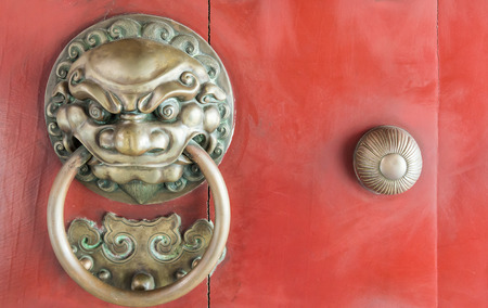 Lion head knocker from the brass in the  Chinese temple door.の写真素材