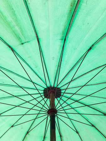 Old metal frame inside the old umbrella on the beach.の写真素材