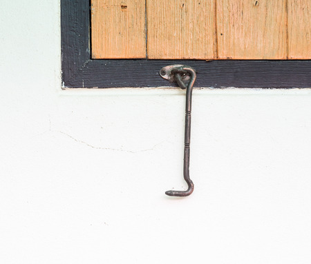 Old metal hook under the wooden window of the Thai Temple.の写真素材