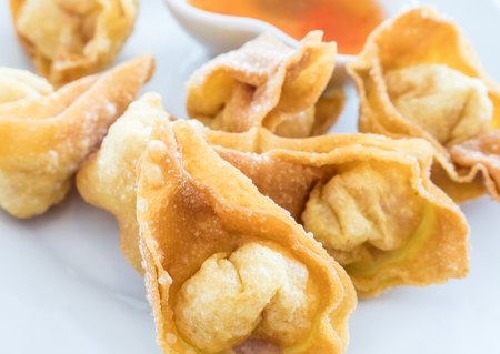 Crispy fried wonton with the pork in the traditional Thai style and the sweet chili sauce on the white plate.(Select focus)の写真素材