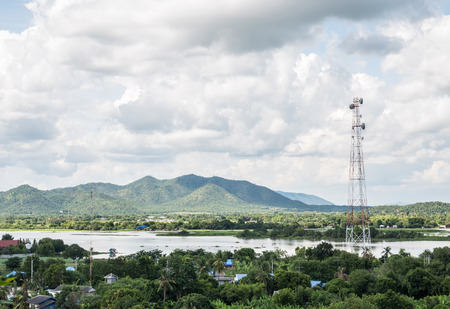 Telecommunication tower in the rural village near the large river, western of Thailand.