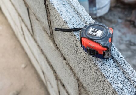Old measuring tape on the block wall of the unfinished house.の写真素材