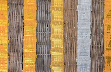 Fabric flag in the traditional northern region style of Thailand is hanging on the bamboo wall near...