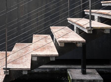 Modern staircase with the metal wire leader over the small pond in the exhibition hall.の写真素材