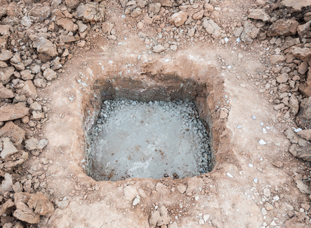 Small hole with the cement layer for built the concrete pillar of the new garage.