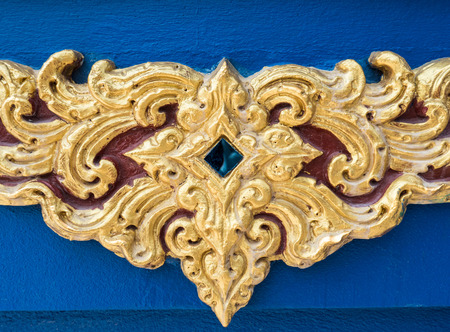 Traditional Thai pattern of the golden stucco on the church wall in the Thai temple.の写真素材