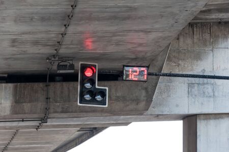 Red light from the signal pole with the digital countdown number in the intersection under the expressway bridge.の写真素材
