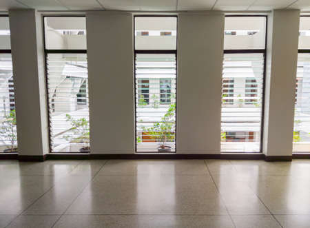 The empty tranquility walkway along the marble pattern corridor with the soft light from the window,...