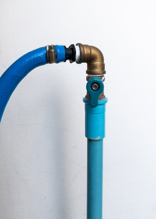 The small brass valve to control the flow of water for use in the outdoor kitchen near the white wall, front view with the copy space.の写真素材