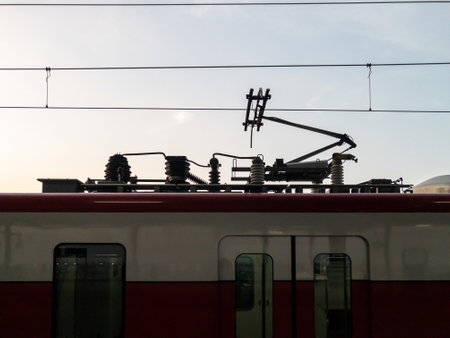 The pantograph to connect the electric power line of the modern commuter train near the platform in the station for, front view with the copy space.の写真素材