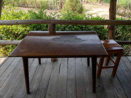 The minimal style of the teak table and stool on the terrace of the wooden house in the countryside village, front view with the copy spaceの写真素材
