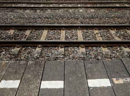 The double railway line along the temporary platform with the signal line to caution passengers in the urban area, front view with the copy space.の写真素材