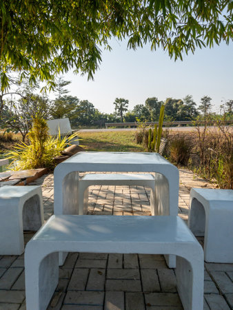 The terrazzo table and chair are set on the terrace with the small garden of the local coffee shop...