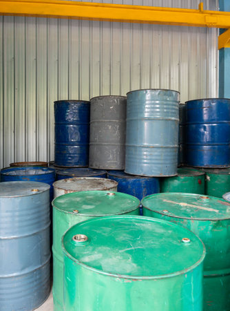 Neatly arranged oil drums stored in a factory warehouse, highlighting industrial storage and...
