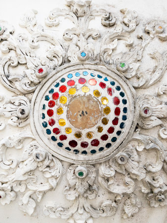 Stunning Thai plaster wall art with vibrant glass mosaics, perfect for temple decor. This intricate, sacred design showcases cultural heritage and craftsmanship, ideal for stock photo collections.の写真素材