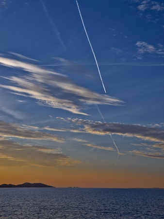 Islands, clouds and jet traces in twilightの写真素材