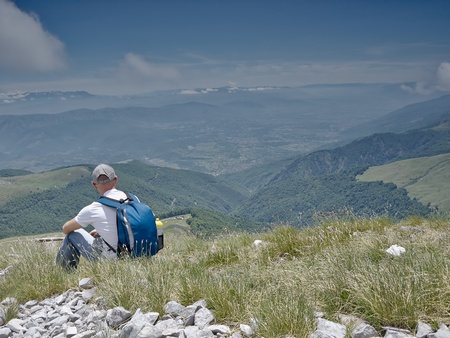 Man sitting in a meadow in the mountainの写真素材
