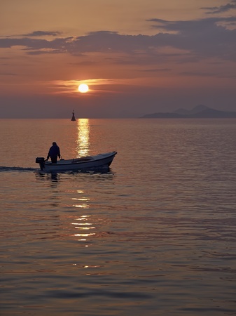 Fisherman at sunset returns home       の写真素材