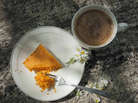 Pumpkin cheese cake on the stone table with cup of coffeの写真素材