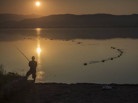 silhouette of a fisherman at sunriseの写真素材