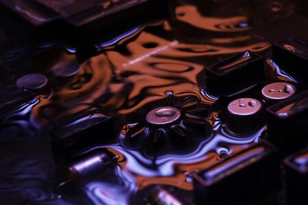 Closeup of electronic hardware. assembly on the circuit board with dark red and blue reflection,...
