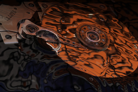 Opened Computer hard disk drive in studio with bubbles and dark red and blue reflection, conceptual creative associationの写真素材