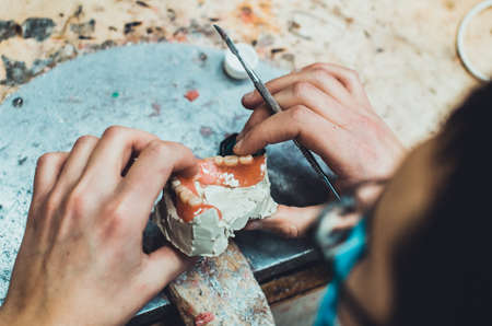 Close-up of the hands of a man cutting a piece of cheese