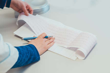 Close-up of a woman writing in a notebook with a pen