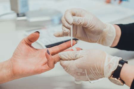 Close-up of the hands of a manicurist in gloves and gloves.