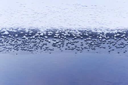 Pattern of ice and snow at frozen river edgeの写真素材