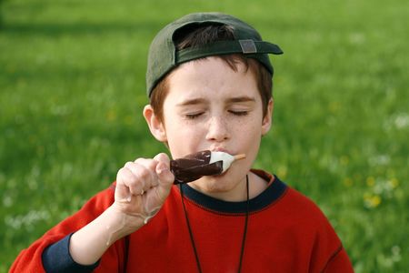 boy eating ice cream on a stick, wolf downの写真素材