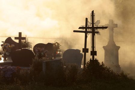 All Saints, cemetery at sunset with cross and silhouetted against sky, の写真素材