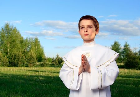 Boy portrait in his first holy communion, praying hands, clear conscienceの写真素材