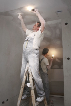 Man plastering wall with work toolsの写真素材