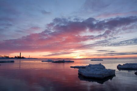Sea on sunset in winter wih iceの写真素材