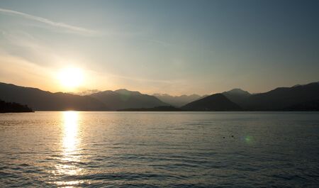 Mountains near lake with sunの写真素材
