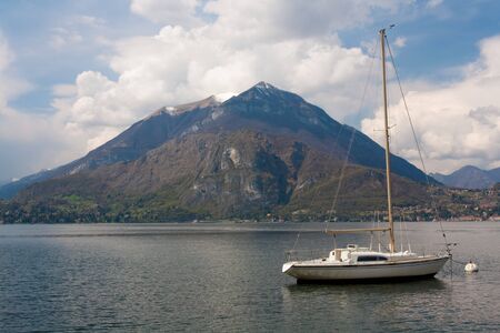 Mountains near lake with boats and housesの写真素材