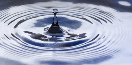 Water drop splashing macro with wavesの写真素材